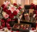 Premium luxury gift hamper featuring elegant red and pink flower arrangements, assorted gourmet chocolates, decorative gift boxes, candles, and sophisticated packaging, ideal for luxury flower and chocolate gift delivery in Pakistan.